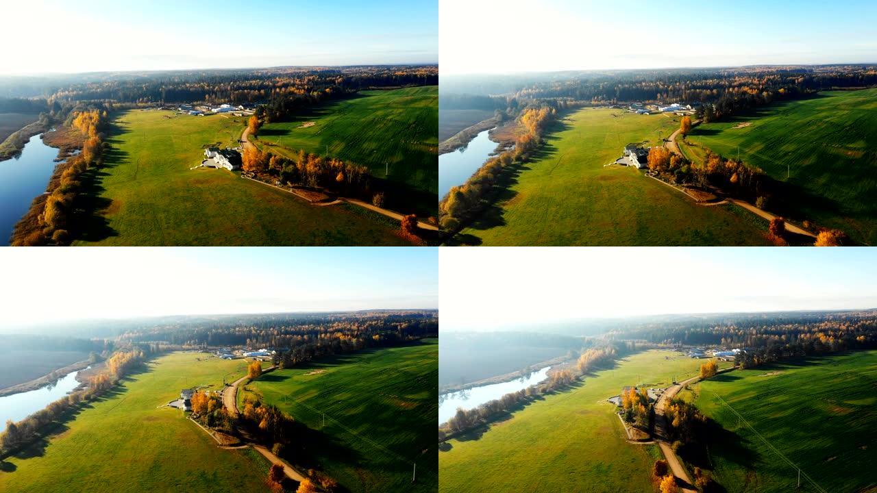 晴天，无人驾驶飞机在令人惊叹的田园秋天，日出湖和大乡村农场的森林上方平移。