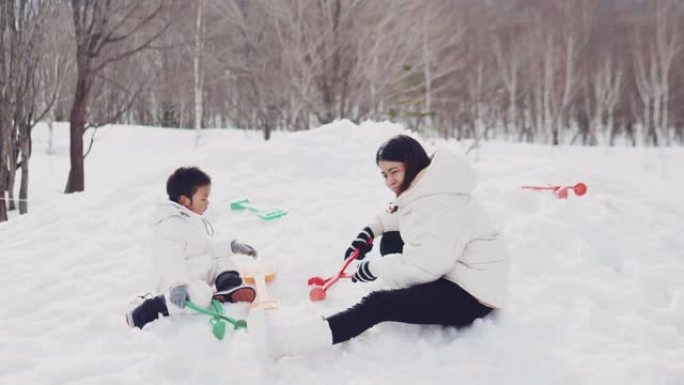 旅游妇女和儿童在雪地里玩耍