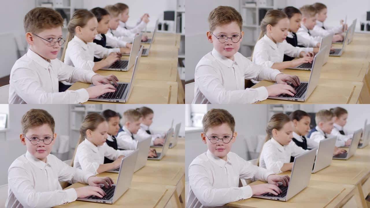 戴着眼镜的白人男生在计算机课上微笑