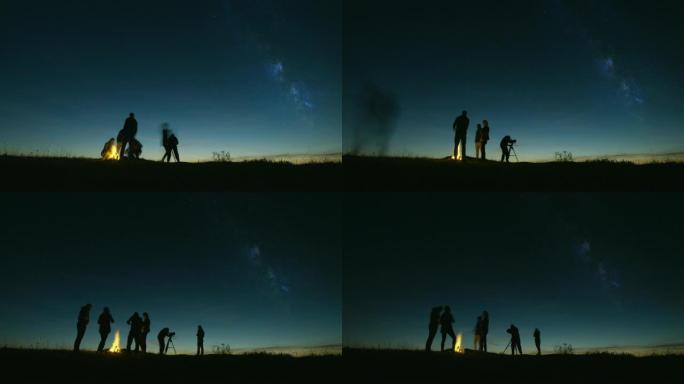 晚上在银河系上通过望远镜看篝火的朋友