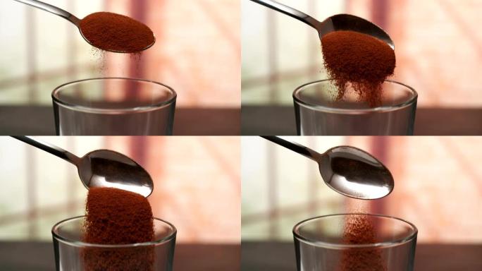 汤匙磨碎的咖啡掉入玻璃杯中
