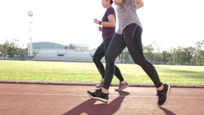 在跑道上训练的两名女跑步者的腿