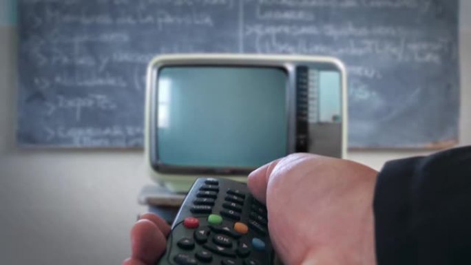 男的手打开学校的旧电视。