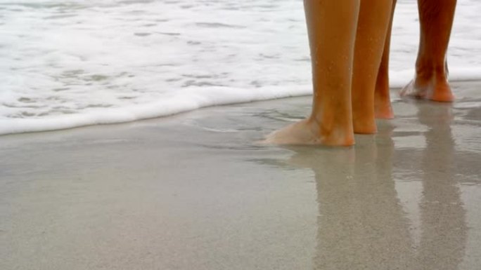 低矮的情侣赤脚站在海滩4k