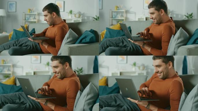 男子躺在家里的沙发上，使用带有绿色模拟屏幕的笔记本电脑。在客厅匿名男子的肩膀上。慢动作。