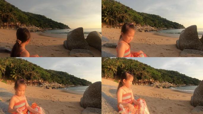 快乐的儿童女孩在日落时在美丽的海滩上玩耍