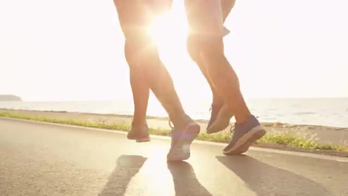 镜头耀斑: 不知名的年轻女性和男性，双腿在阳光下慢跑。