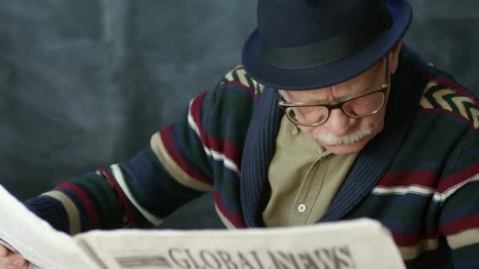 戴着帽子的老人阅读报纸