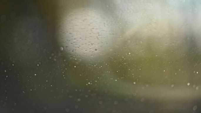 用液体和汽车雨刷清洗汽车挡风玻璃。许多小飞溅覆盖了玻璃表面。慢动作镜头