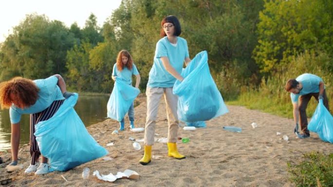 多民族学生从美丽的湖泊海滩收集垃圾