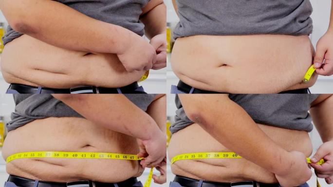 超重的人用卷尺检查他的身体超重。健康的概念。真实的身体