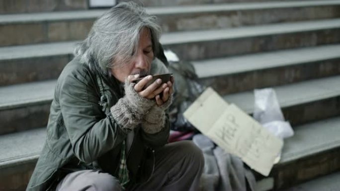 人们在人行道上给无家可归的人食物。