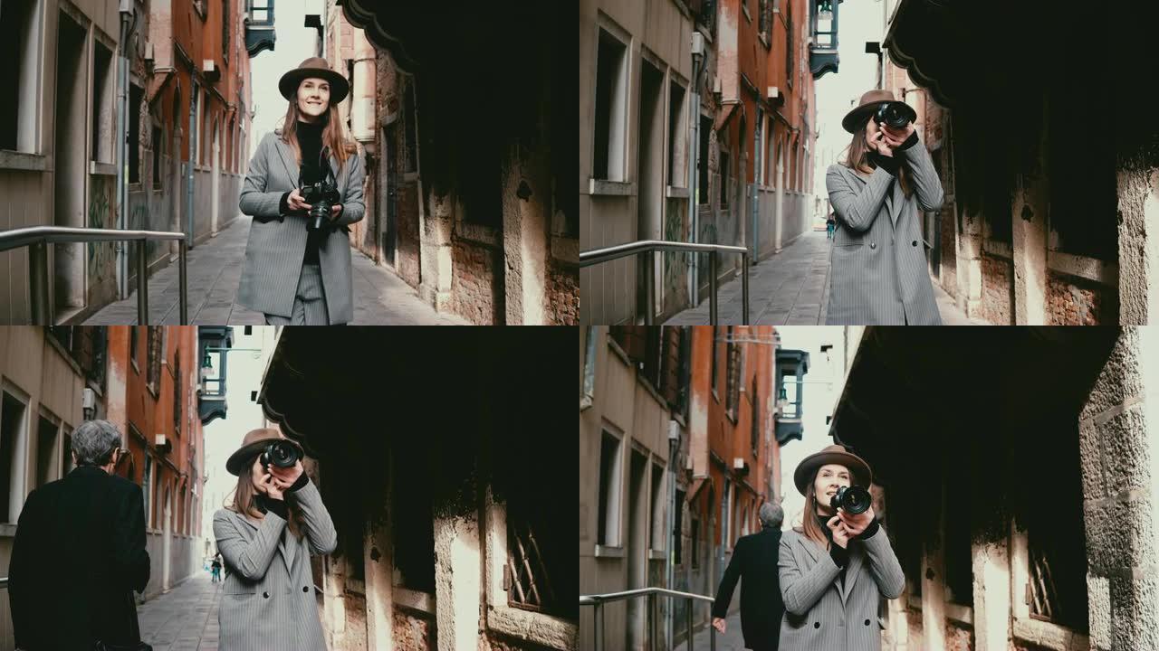 迷人的快乐职业记者女人在意大利威尼斯美丽的街道上与相机同行，拍照。