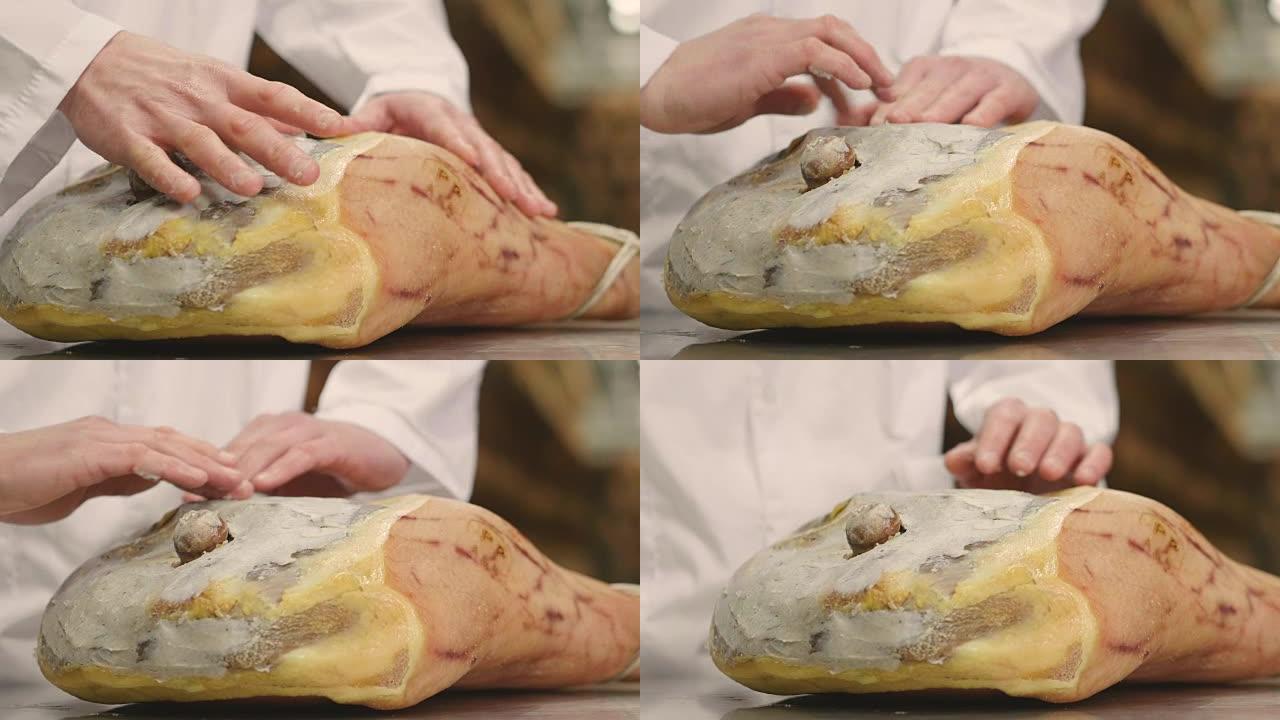 正如意大利古代传统所教导的那样，在调味之前，用脂肪收集火腿的手的特写镜头，以赋予风味并保护霉菌。