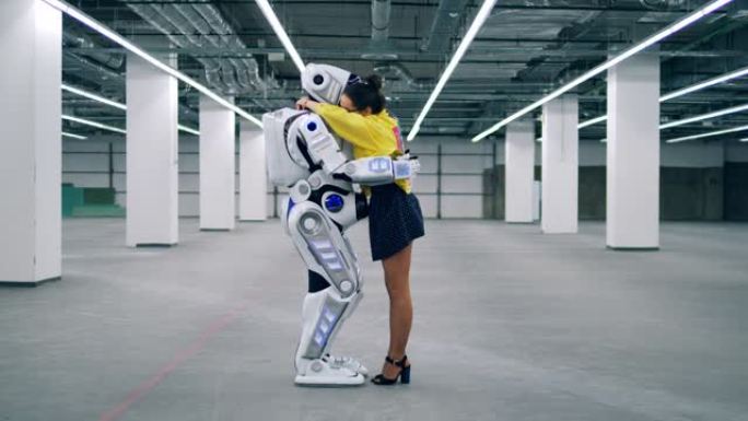 机器人和女人互相拥抱，站在一个空房间里。