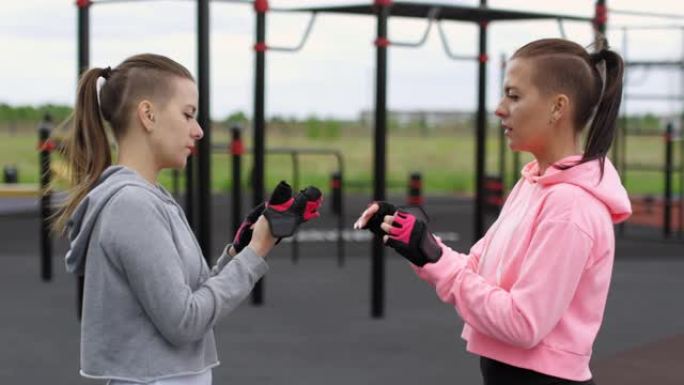 运动双胞胎姐妹准备在室外体育场锻炼