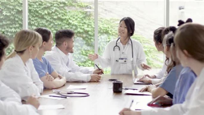 亚洲女医生在医院团队会议上领先