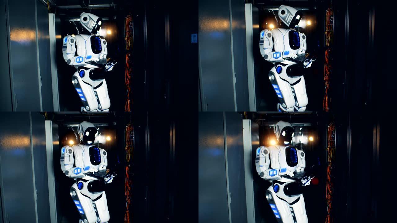 白色机器人在数据中心与笔记本电脑一起工作，特写镜头。