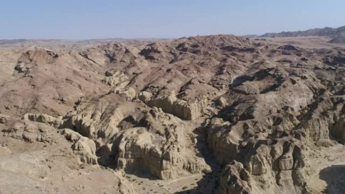 一辆野生动物园车辆的4k空中倾斜视图，让游客看到纳米比亚纳米布沙漠的古老地质岩层