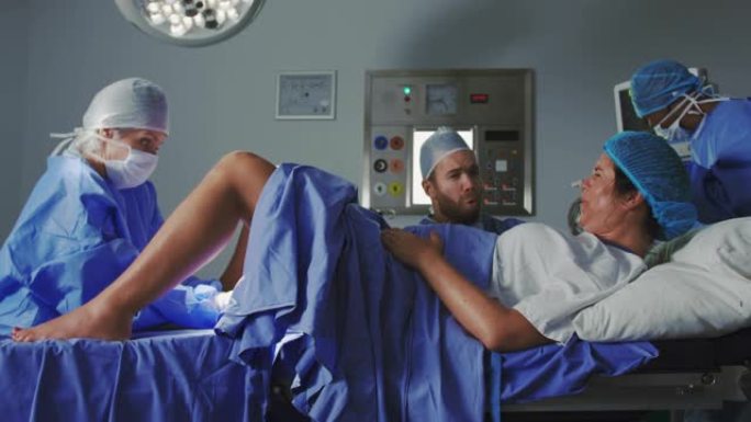 高加索女外科医生在手术室中检查孕妇的侧视图