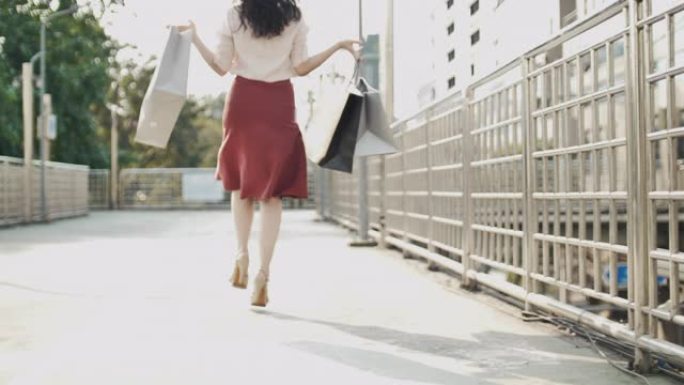 购物狂女人快乐购物用购物袋跳跃