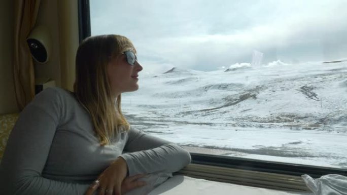 特写: 年轻女子在乘火车时观察风景秀丽的白雪皑皑的喜马拉雅山。