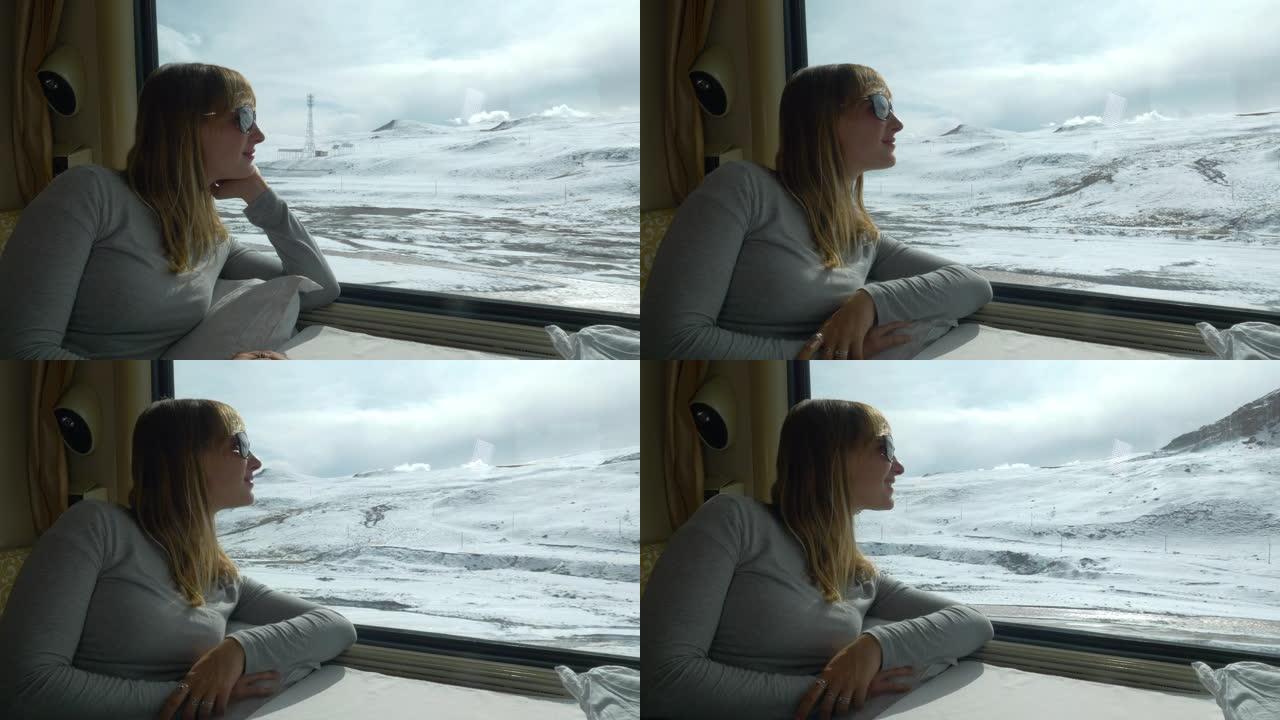 特写: 年轻女子在乘火车时观察风景秀丽的白雪皑皑的喜马拉雅山。
