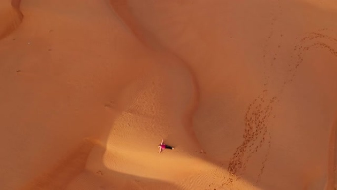 空中深情的女人躺在沙丘上