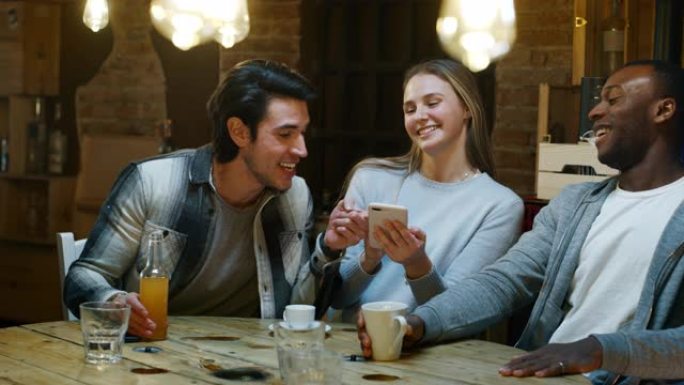 微笑的朋友在咖啡馆喝咖啡，玩手机的慢动作。