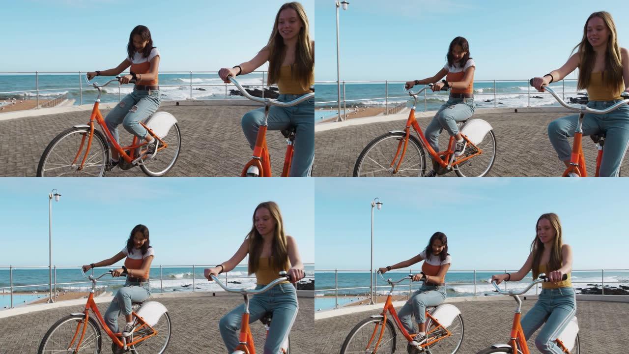 高加索人和混血女孩骑自行车海边的侧视图