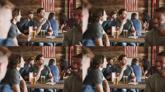 一群男性朋友在体育酒吧聚会喝啤酒聊天