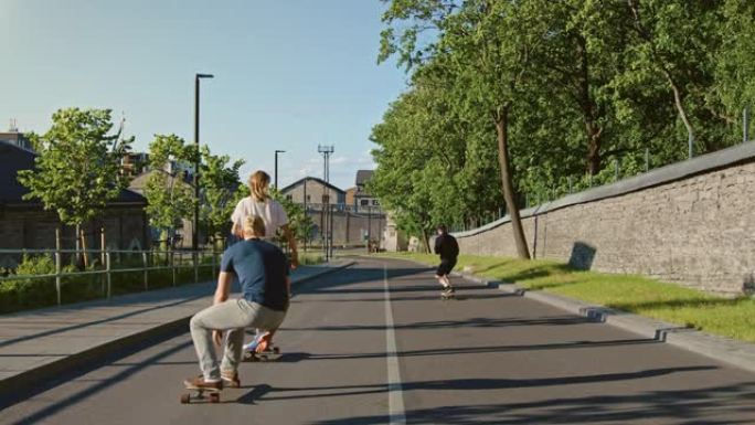酷的年轻女孩和两个男人骑着长板和滑板穿过城市时尚的臀部文化部分。在时髦区的路上滑板。在慢动作相机拍摄