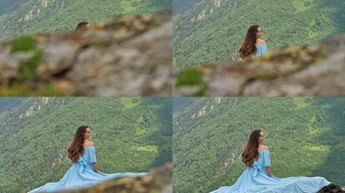 穿着优雅礼服的女人坐在岩石上。山地景观