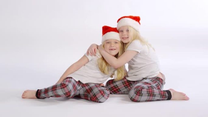 抱着圣诞老人帽子的双胞胎姐妹