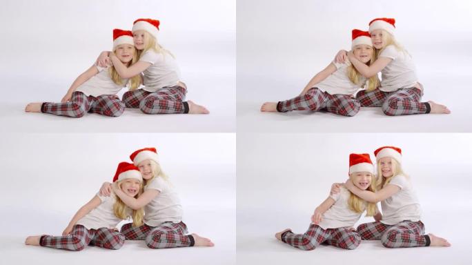 抱着圣诞老人帽子的双胞胎姐妹