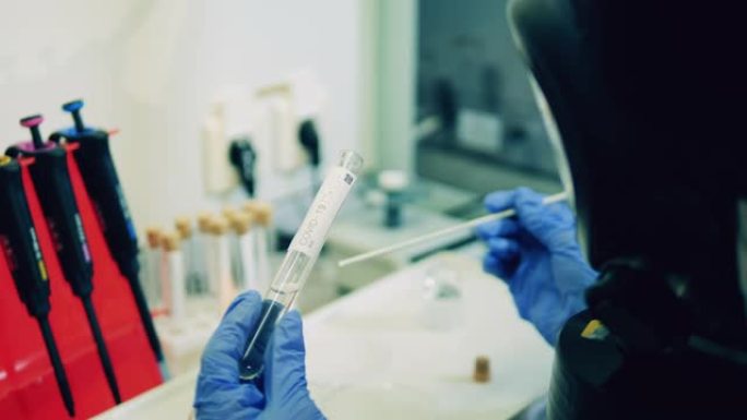 一名实验室工作人员正在分析covid-19检测玻璃管。科学家检测Covid-19、冠状病毒样本。