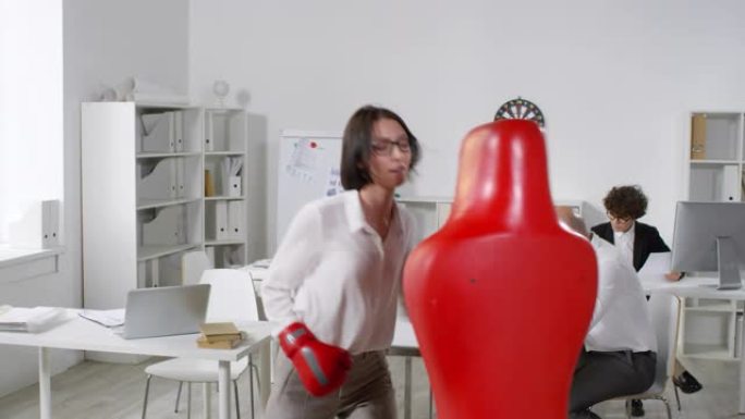 Young Brunette员工Punching Boxing Dummy