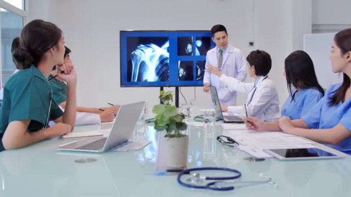 医生在会议上展示x射线，年轻实习生在医学会议上听医生的演讲。在会议室工作的医务工作者。医学教育，保健