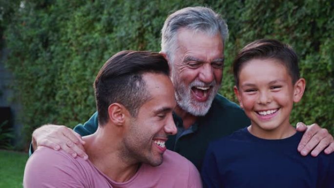 花园中多代男性西班牙裔家庭的肖像在镜头前微笑