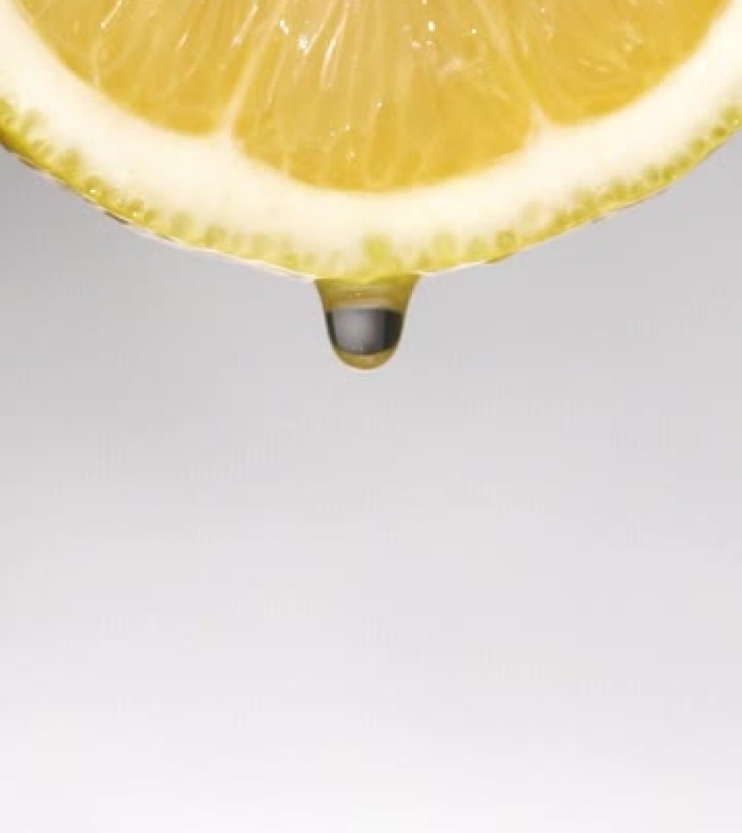 垂直和慢动作: 一滴柠檬片上的白色液体