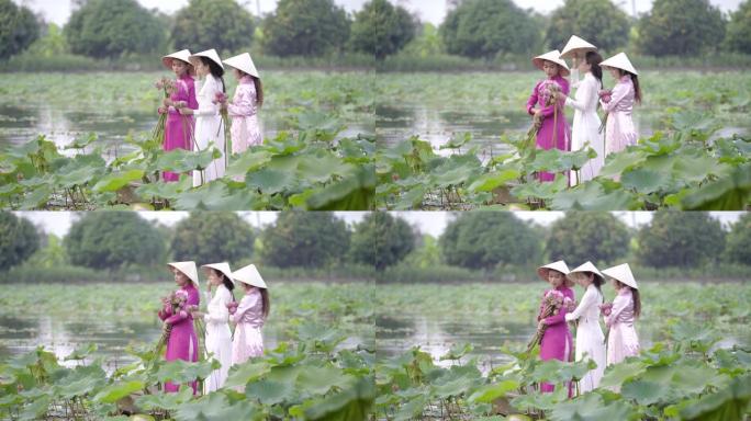 一个穿着越南民族服装或奥黛文化传统的年轻女子站在船上，在荷花花园里。越南