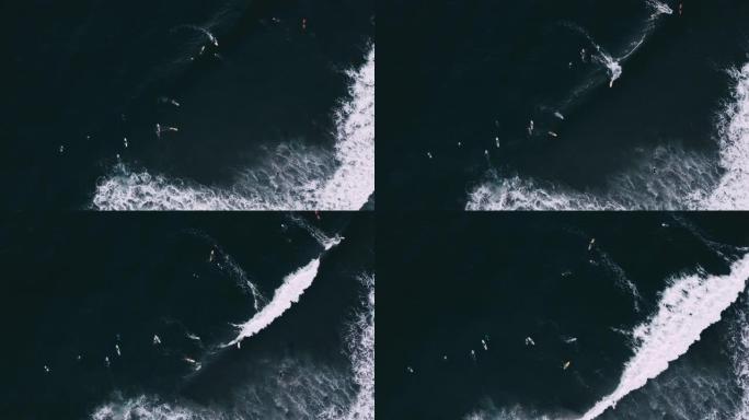 海浪撞击和冲浪者乘浪的俯视图