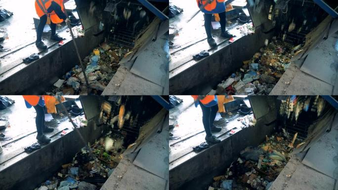 工人正在从运输皮带上清除不合适的垃圾