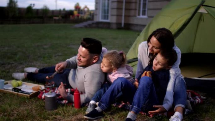 可爱的高加索家庭在后院享受晚间野餐
