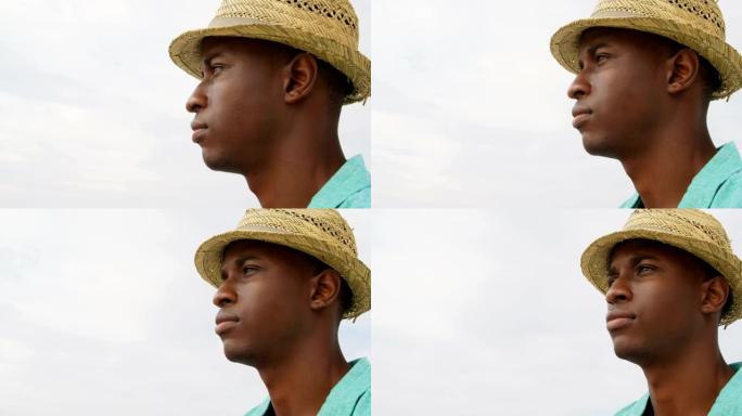 站在海滩上的帽子中的非洲裔美国人的侧视图4k