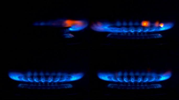 燃气灶上点燃的火。从完全黑暗的状态中，蓝色的气体火焰慢慢点燃，带来温暖和热量。慢动作特写镜头