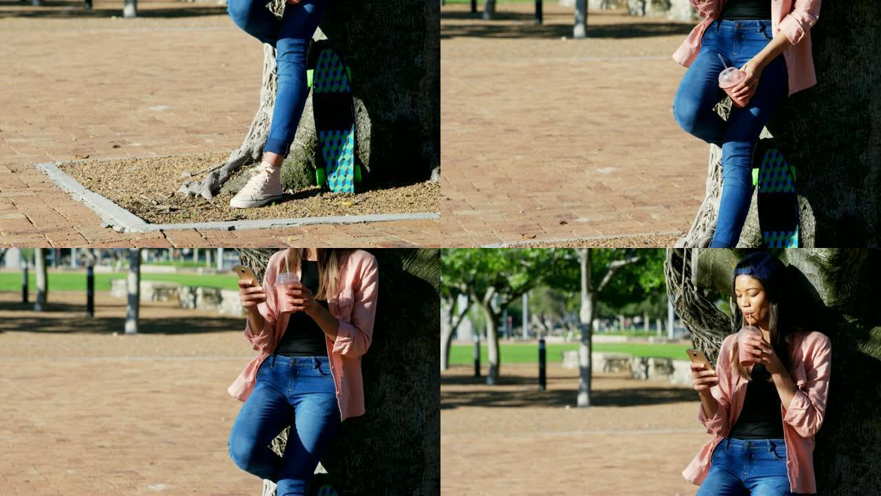 在4k公园喝果汁时使用手机的女人