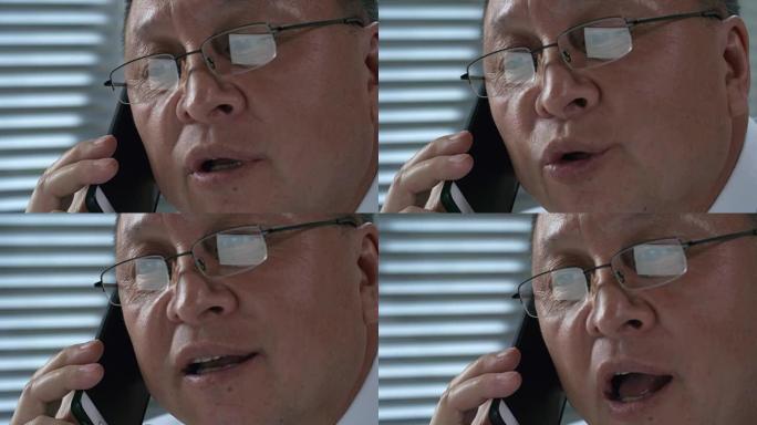 脸部亚洲男子的特写镜头在电话中交谈