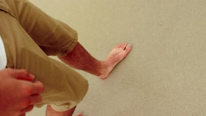 低矮的男人赤脚在海滩上行走4k