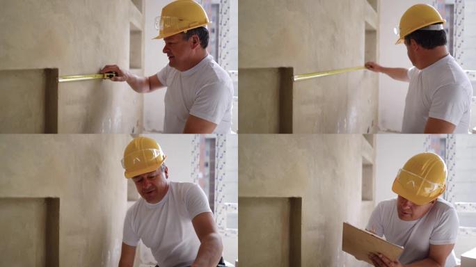 建筑工人在进行家庭装修时测量墙壁